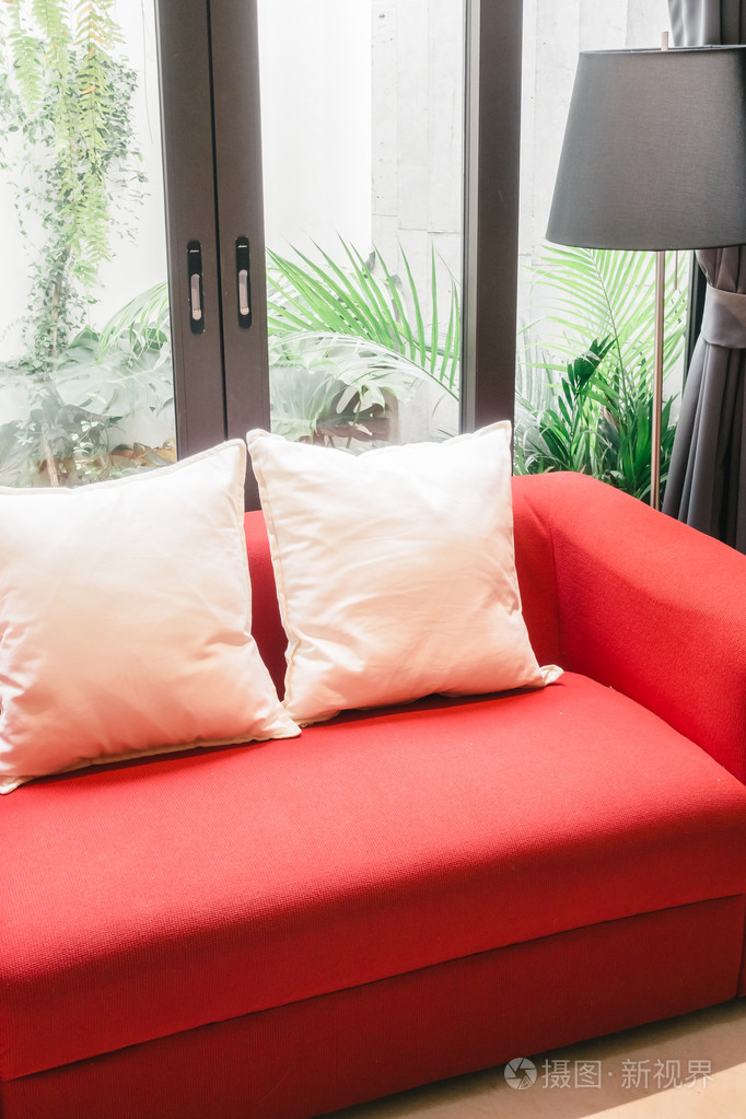 红色的沙发上，用枕头和灯