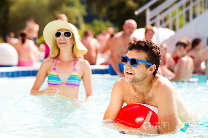 夫妇带着太阳眼镜在游泳池