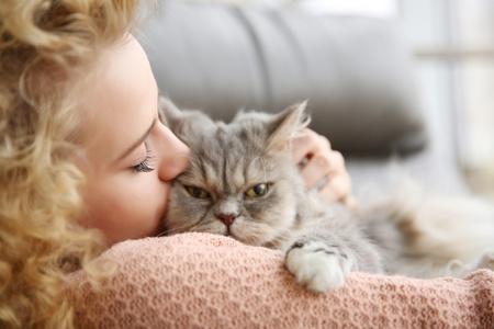 女人和猫在房间里的沙发上