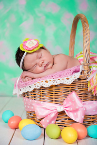 刚出生的婴儿女孩在柳条篮子有甜蜜的梦。复活节假期