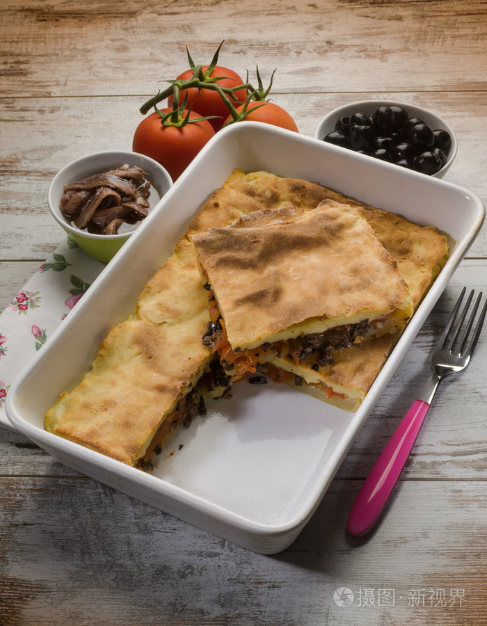 意式薄饼塞满了黑橄榄番茄和凤尾鱼