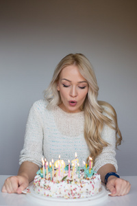 bautiful 白人女孩吹在她的蛋糕上的蜡烛