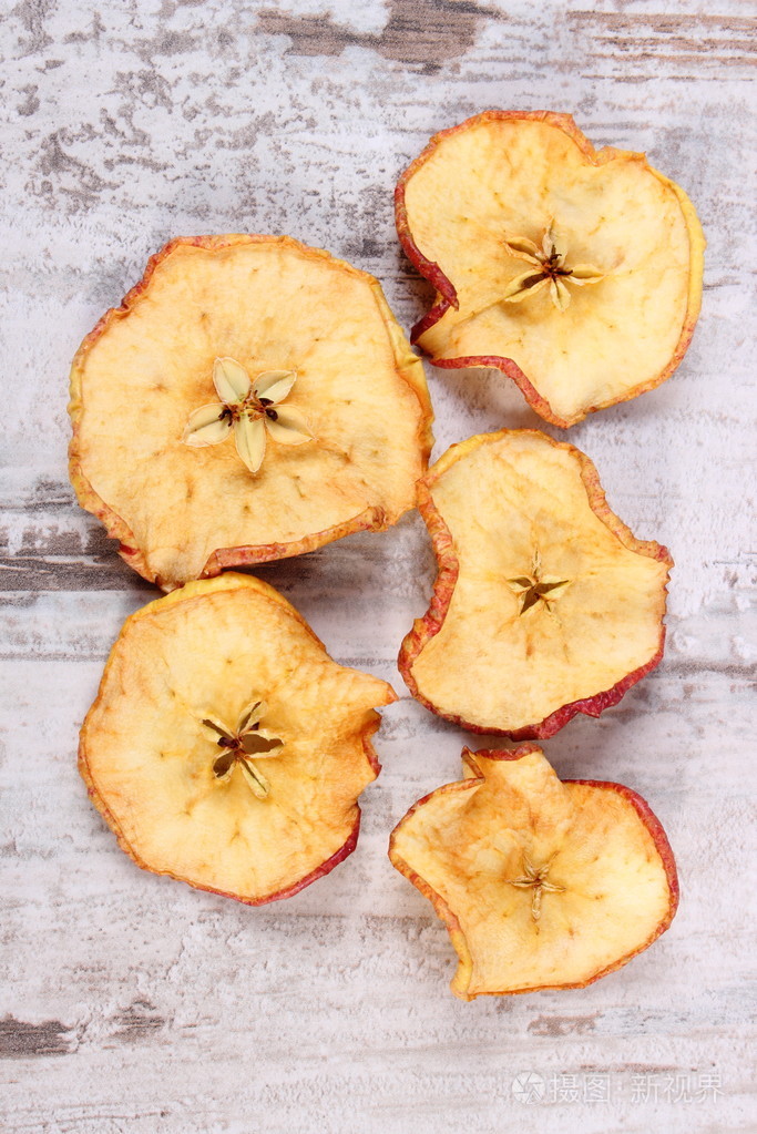 旧仿古木制背景上的干苹果片