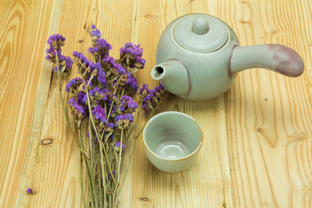 老式的茶壶 茶杯和干花木制背景