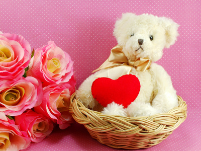 红色的心，在粉红色的背景与篮子里的泰迪熊