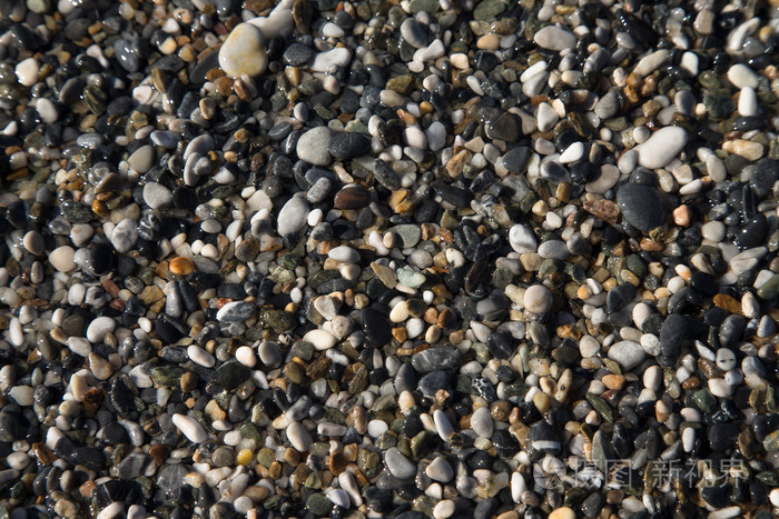 在海岸上的天然卵石的背景。选择性的焦点