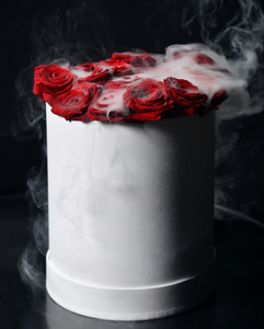 激情绽放一束新鲜的红玫瑰花,在黑色的玫瑰上绽放着明亮的烟雾照片