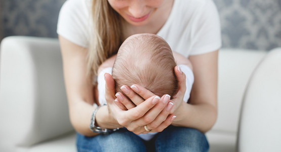 可爱的新生婴儿睡在母亲的怀抱