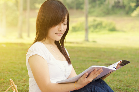 年轻的亚洲大学女学生阅读的书