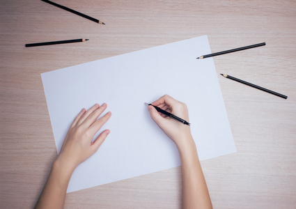 用铅笔在白色纸上写字的手照片
