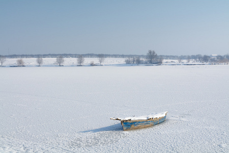 在冰上的旧船。按横向的观点，与冬季景观意