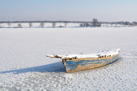 在冰上的旧船。按横向的观点，与冬季景观意