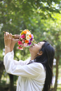 一个年轻漂亮的女人闻鲜花的股票肖像照片