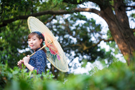 亚洲女孩拿着雨伞在茶园