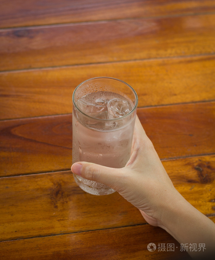 手拿着杯水喝水的玻璃