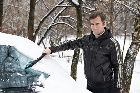 司机用刷子把车里的雪擦干净