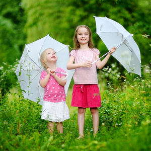 两个可爱的小妹妹在雨中玩耍