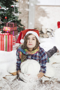 穿着圣诞老人帽子的漂亮年轻女人躺在地板上