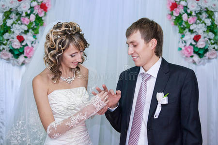 新娘把结婚戒指戴在新郎的手指上