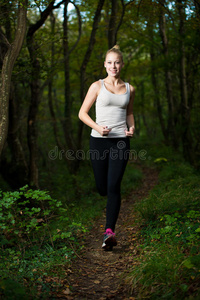 美丽的年轻女子在森林里跑步活跃的跑步者