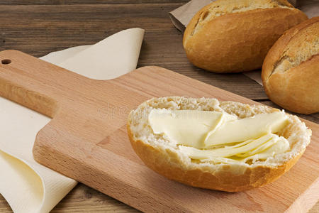早餐板上有黄油的面包和旧木头上的面包卷