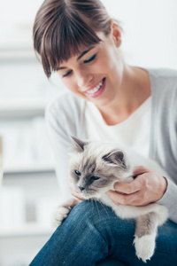 微笑拥抱她的猫的女人