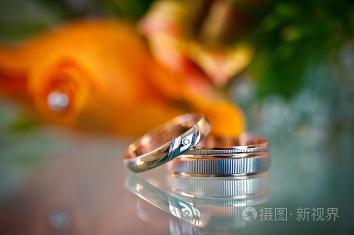 两个漂亮的金戒指，模糊的橙色背景