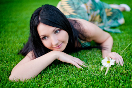 美丽的女人躺在春天草甸草地上