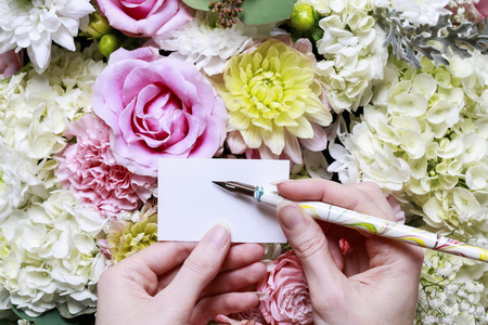 女人控股张空白的纸卡。浪漫的花朵装饰