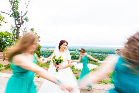 在绿色阳光公园里, 新娘跳舞的肖像和伴娘的乐趣
