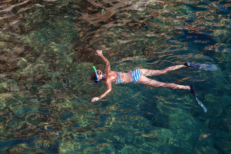 年轻女子在热带环礁湖浮潜