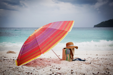 那顶草帽和热带海滩上的包