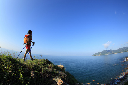 年轻女子徒步旅行海边山峰