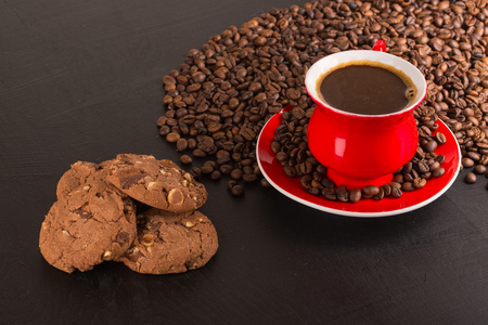 早上好或有一个美好的一天消息概念   明亮红色杯泡沫咖啡与巧克力饼干，咖啡豆
