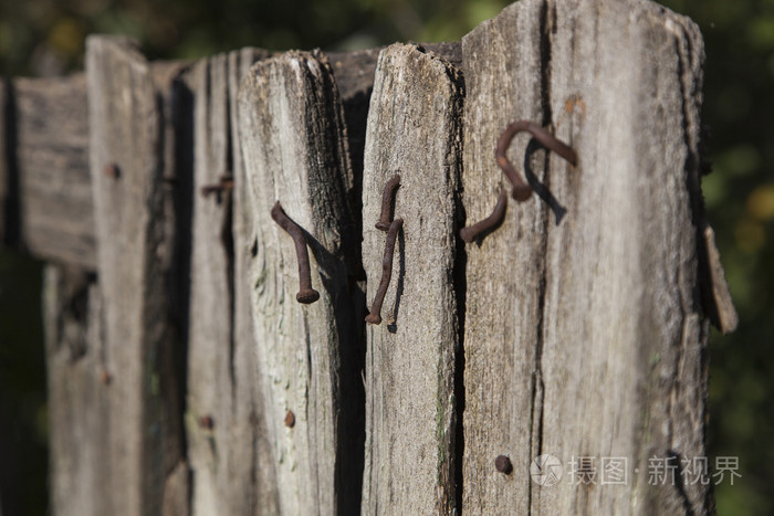 旧破旧的木栅栏的一部分生锈的钉子粘着