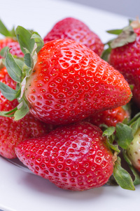 草莓红白色板和一个白色的背景，对比鲜明的形象。顶尖的侧面图。夏季红色浆果