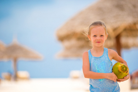 白色的热带海滩上椰子的小可爱女孩