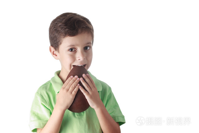 小男孩在白色背景上吃巧克力复活节彩蛋