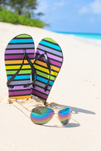 多彩多姿的拖鞋和太阳镜上阳光明媚的海滩