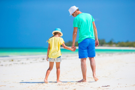 小女孩和年轻父亲在热带海滩度假
