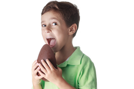小男孩在白色背景上吃巧克力复活节彩蛋