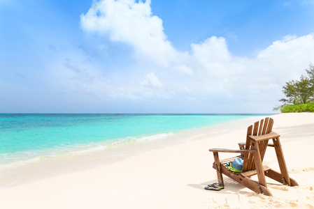木制沙滩椅用帽子和拖鞋在热带海滩，汇总