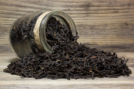 干茶叶红茶和玻璃罐木制背景