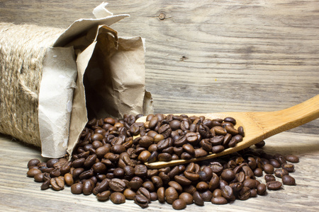 咖啡豆在木勺木制背景