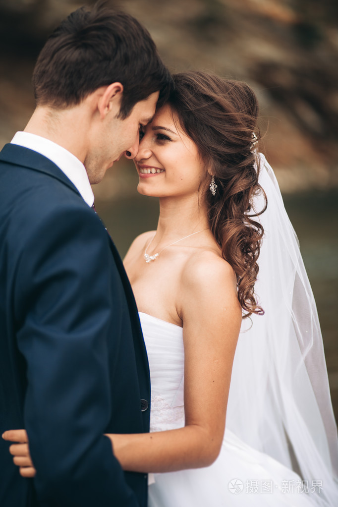 优雅温柔时尚新郎和新娘用石头河附近.婚礼热恋中的情侣