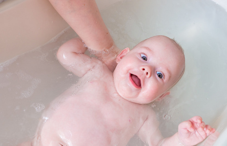 在水浴中的开心宝贝。清洗婴儿概念