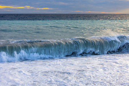 海景观。用梁的日落的太阳点燃的海浪和风暴的波浪线