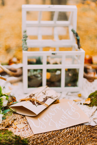 婚礼明信片邀请函桌上的装饰着婚礼的东西。秋天的树林背景