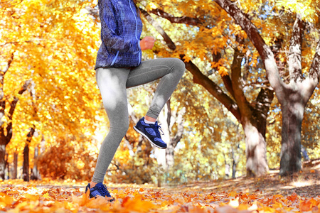 在秋天的公园慢跑的女人