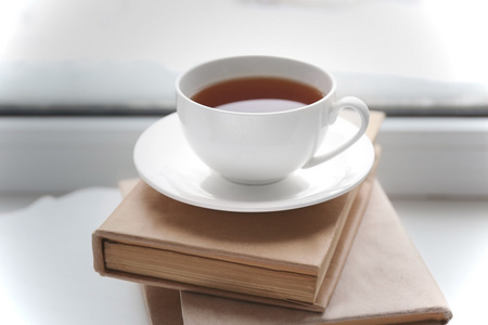 杯茶，书和温暖针织格子在窗台上，靠得很近